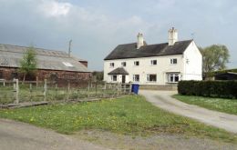 The two-floor farmhouse stands to the north of the farm buildings and is accessed via a tarmacadam driveway with a parking area to the front and side. 