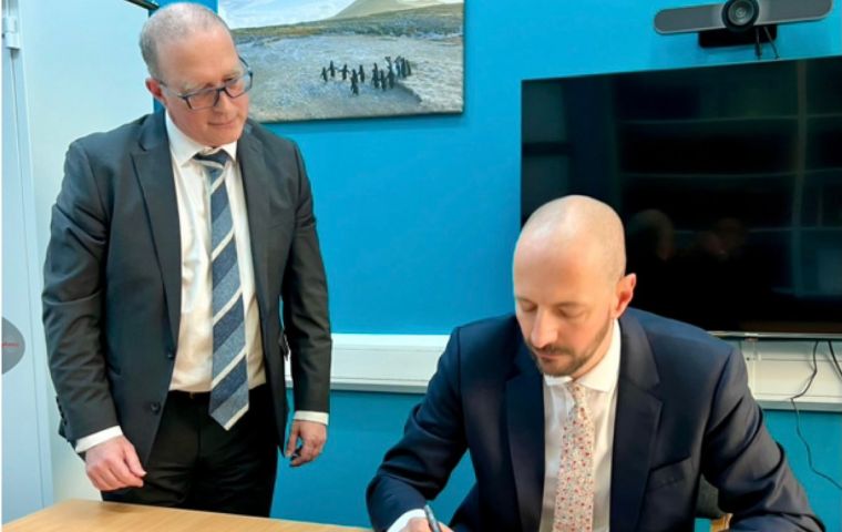 Deputy Director for Overseas Territories Directorate, Adam Pile OBE, signs the documents at Falklands Government House